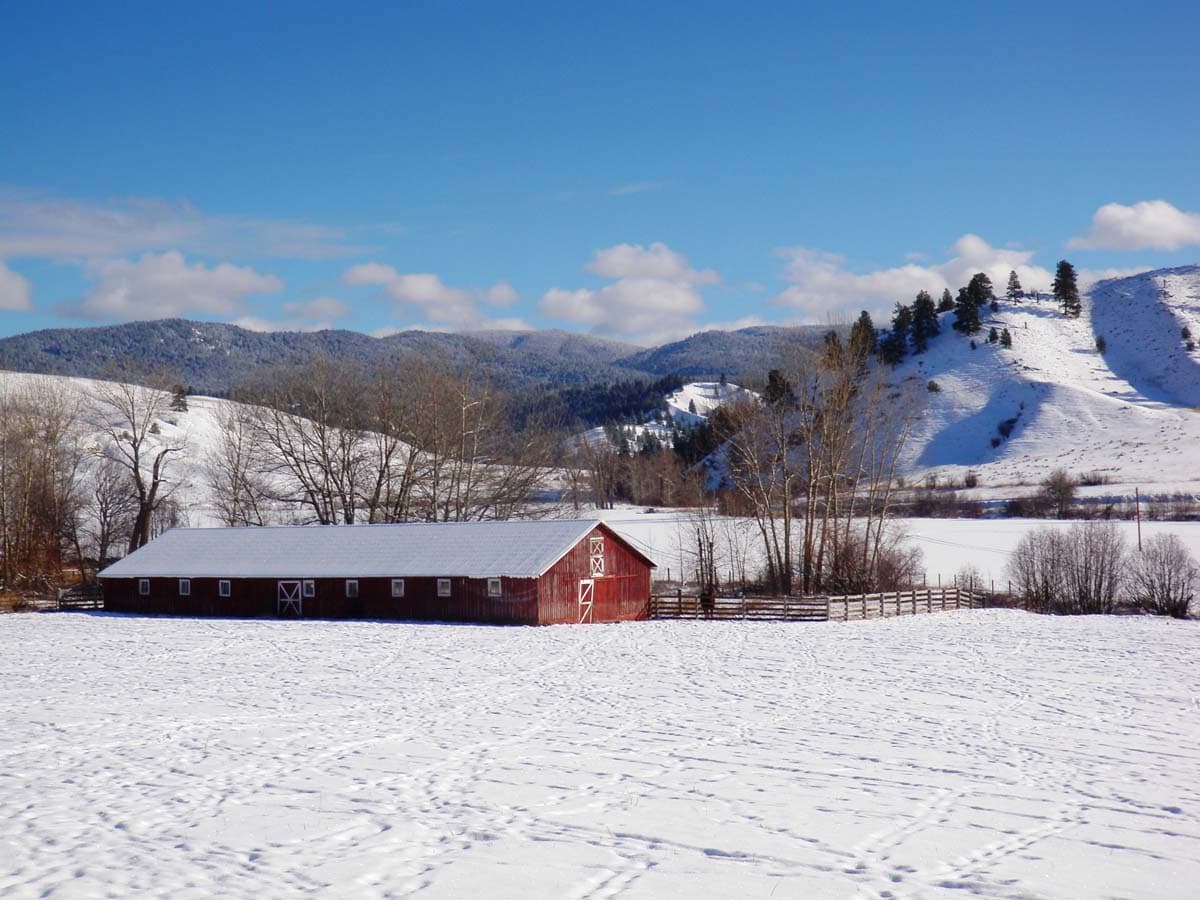 distant red barn snow brown valley ranch