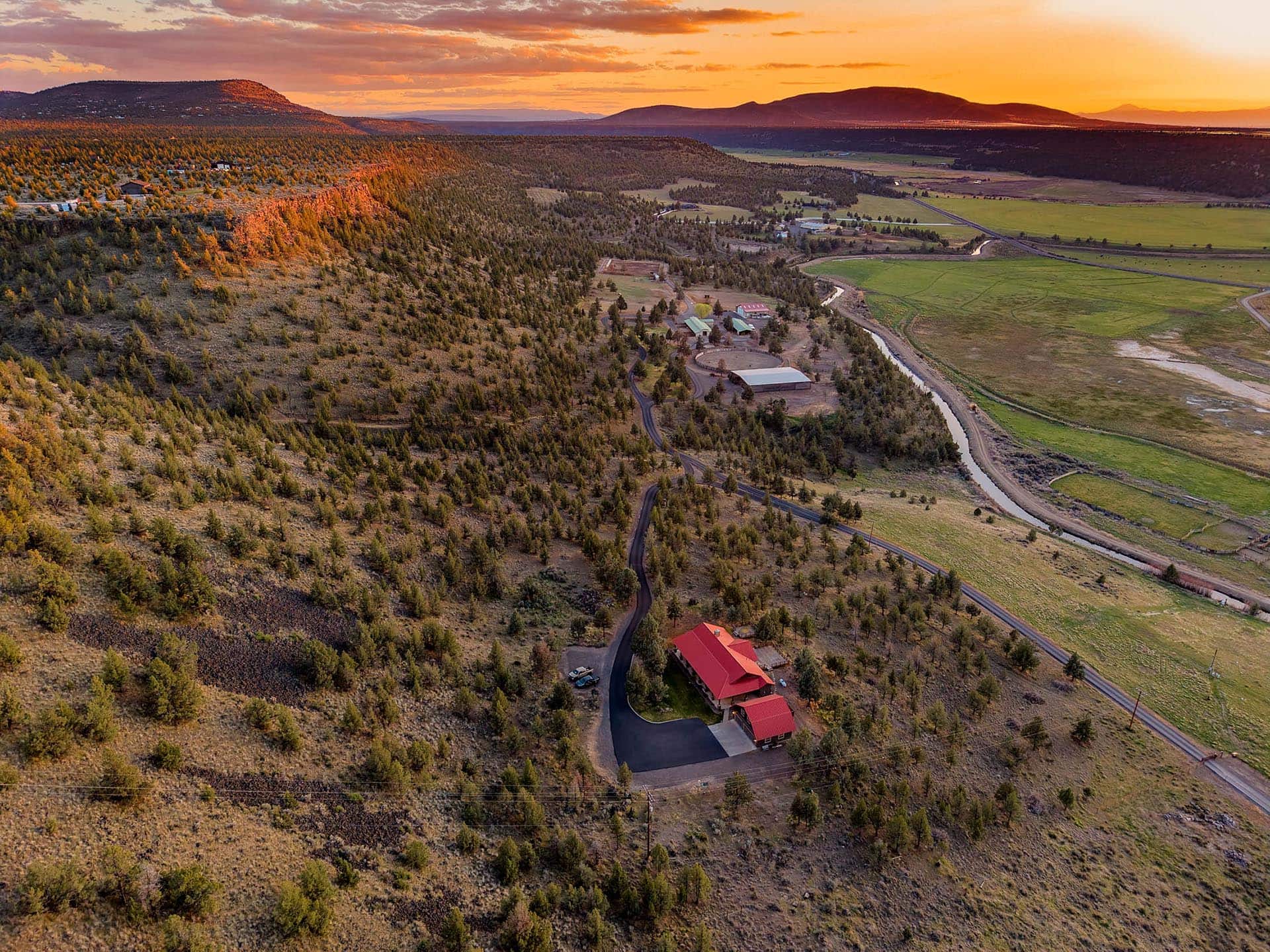 aerial view of ranch home with mountain backdrop at sunset oregon crooked river rim horse ranch