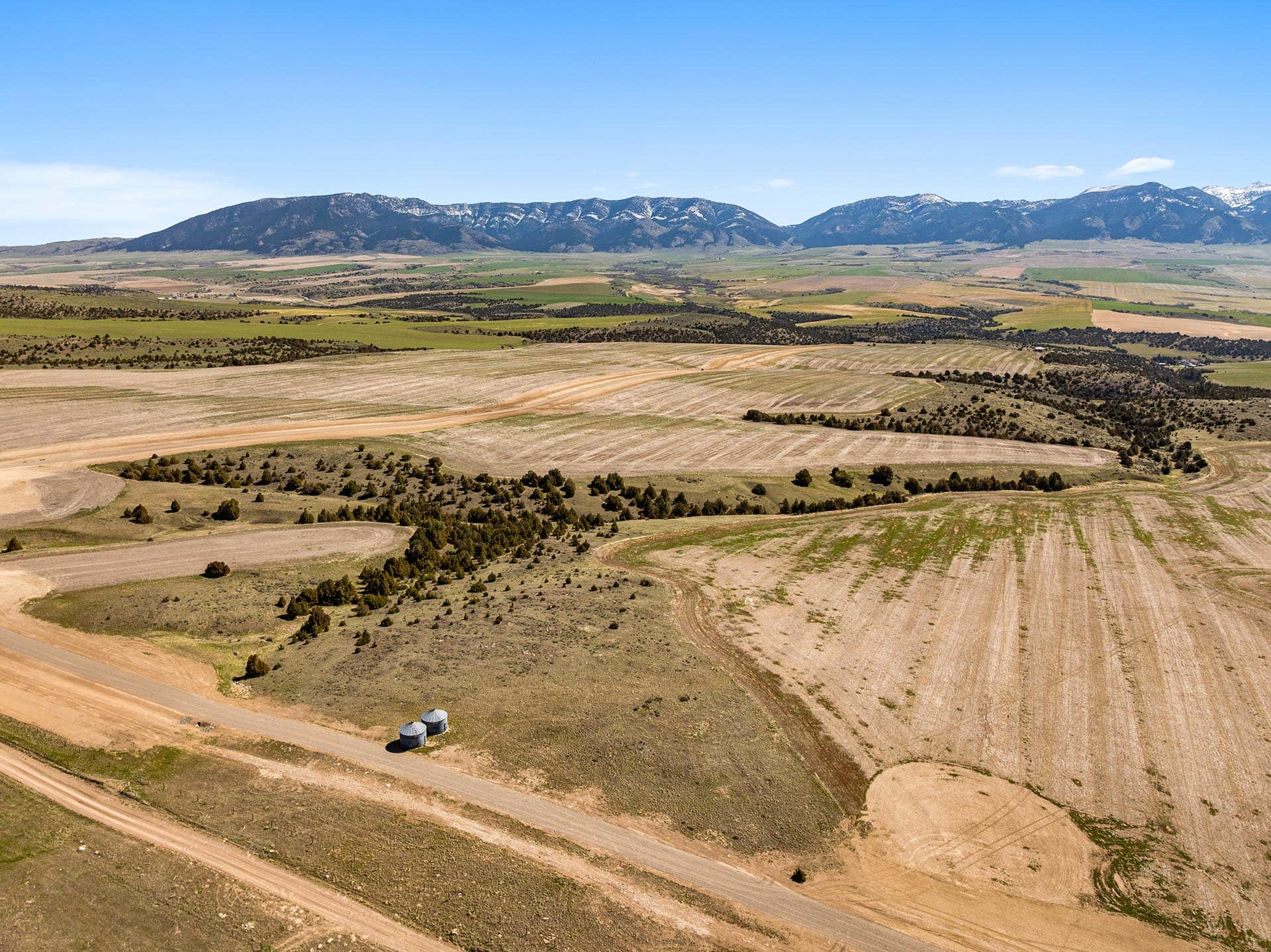 farm land with grain bins and mountain range montana skinner road sanctuary at sxs ranch