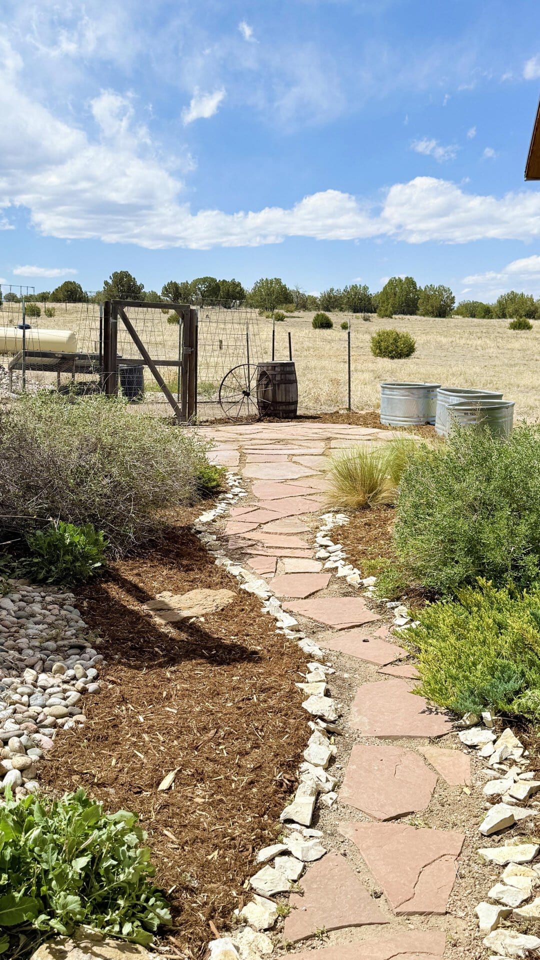 flagstone path with rustic gate and stock tanks colorado mchenry ranch