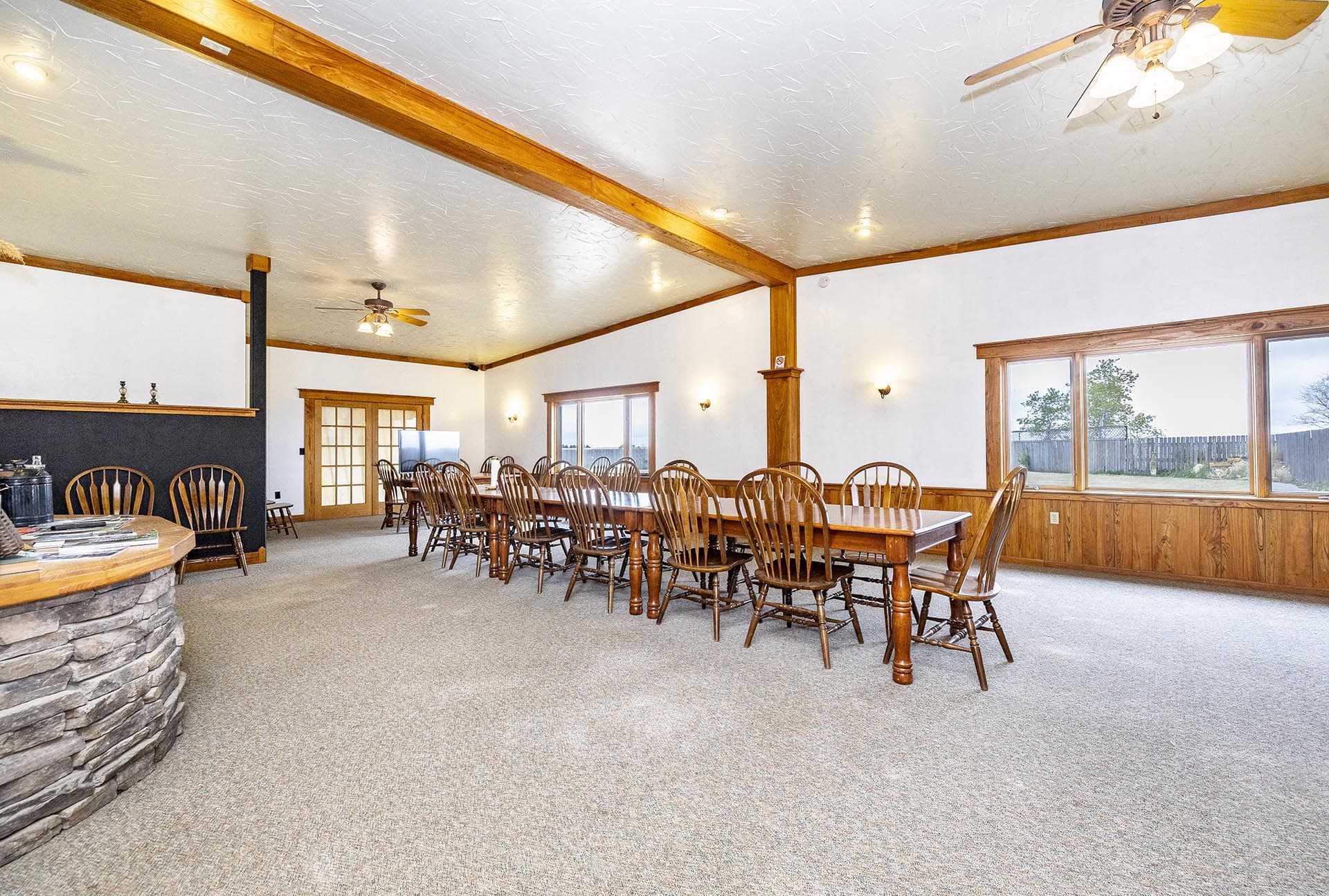 Large conference room with a long wooden table, many Windsor chairs, and rustic wood beams across the ceiling.