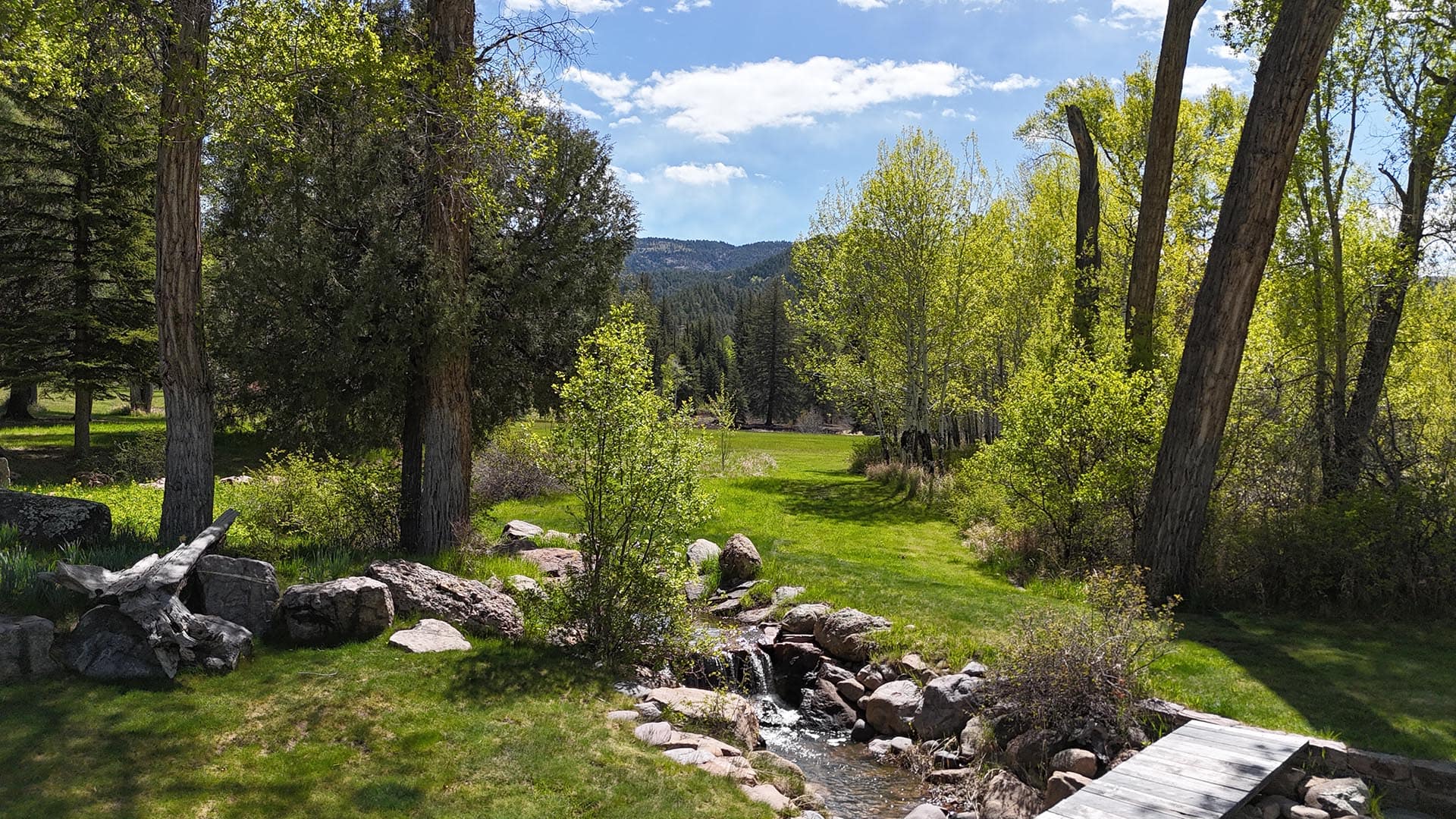 rocky stream with luxh green lawn and trees residential estate new mexico old canones creek ranch