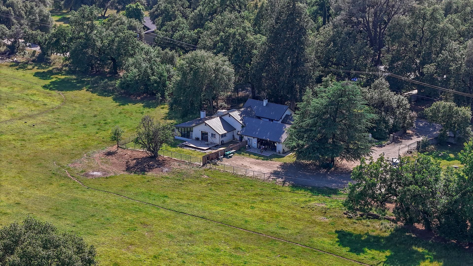 Rural property with lush greenery, trees, and a charming farmhouse in a peaceful setting.