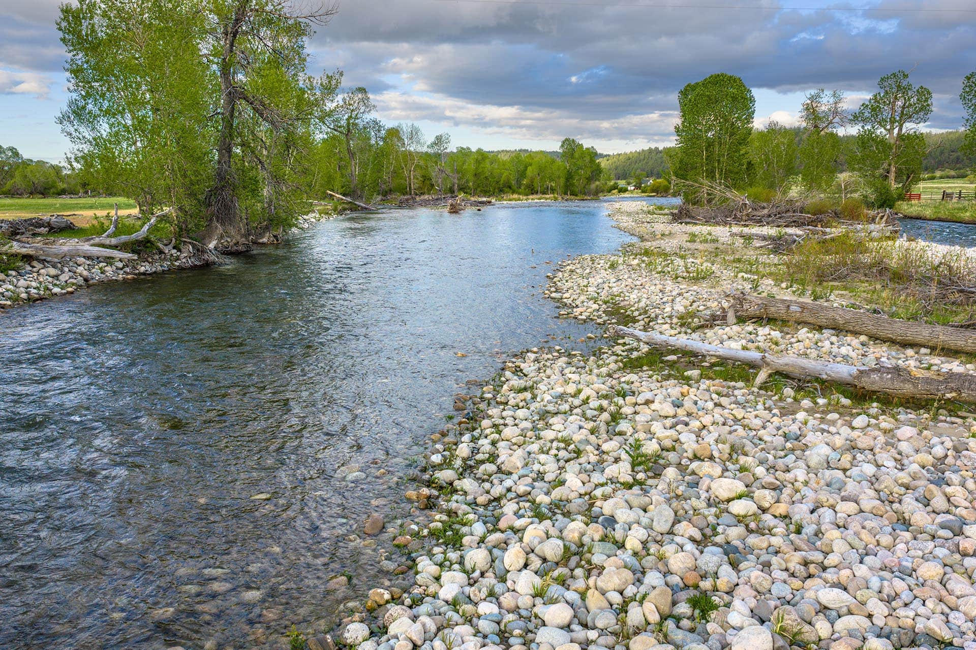 clear river with rocky banks and tress land montana stillwater riffle ranch