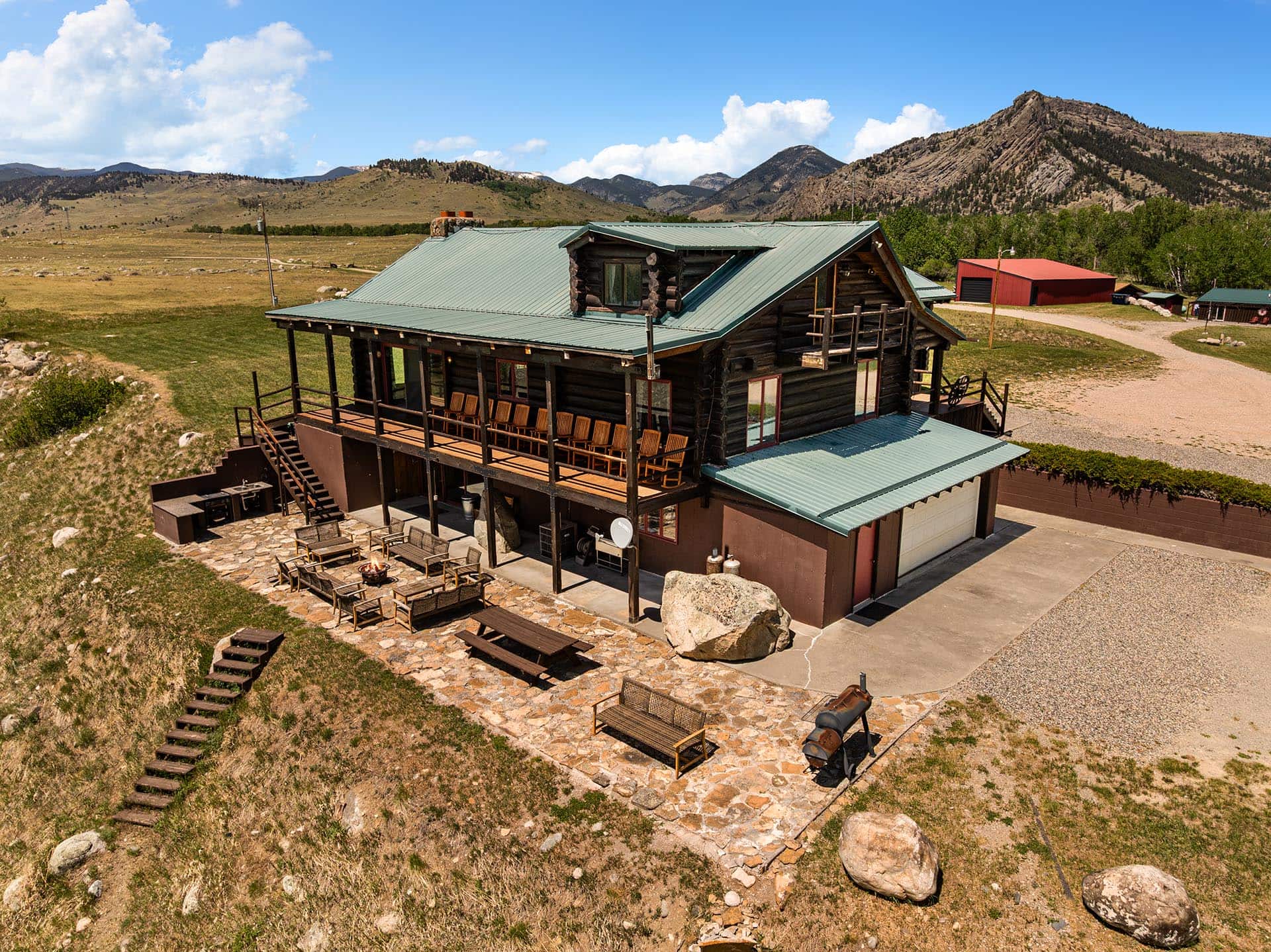 log home exterior with outdoor living space and mountain views for sale montana two rivers lodge