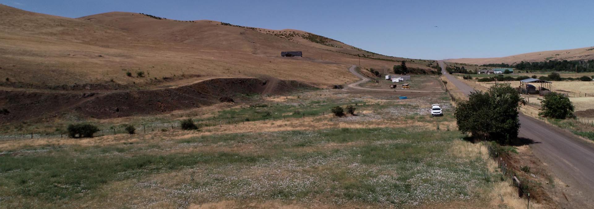 Scenic view of McKay Creek Country Estates with rolling hills and open land.