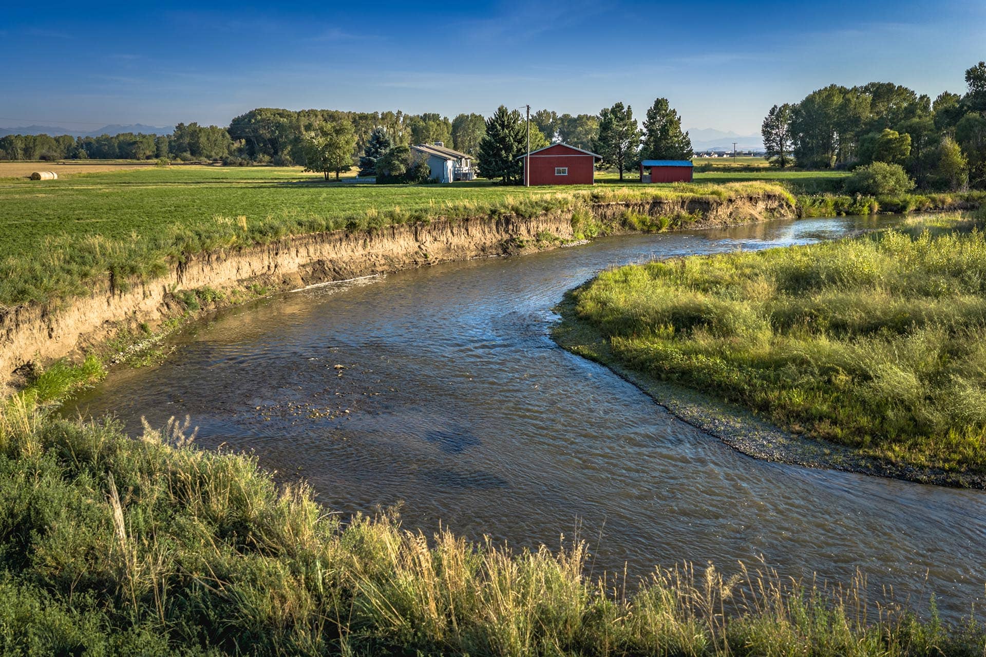 river frontage with hay bale and farm building for sale montana east gallatin riverlands