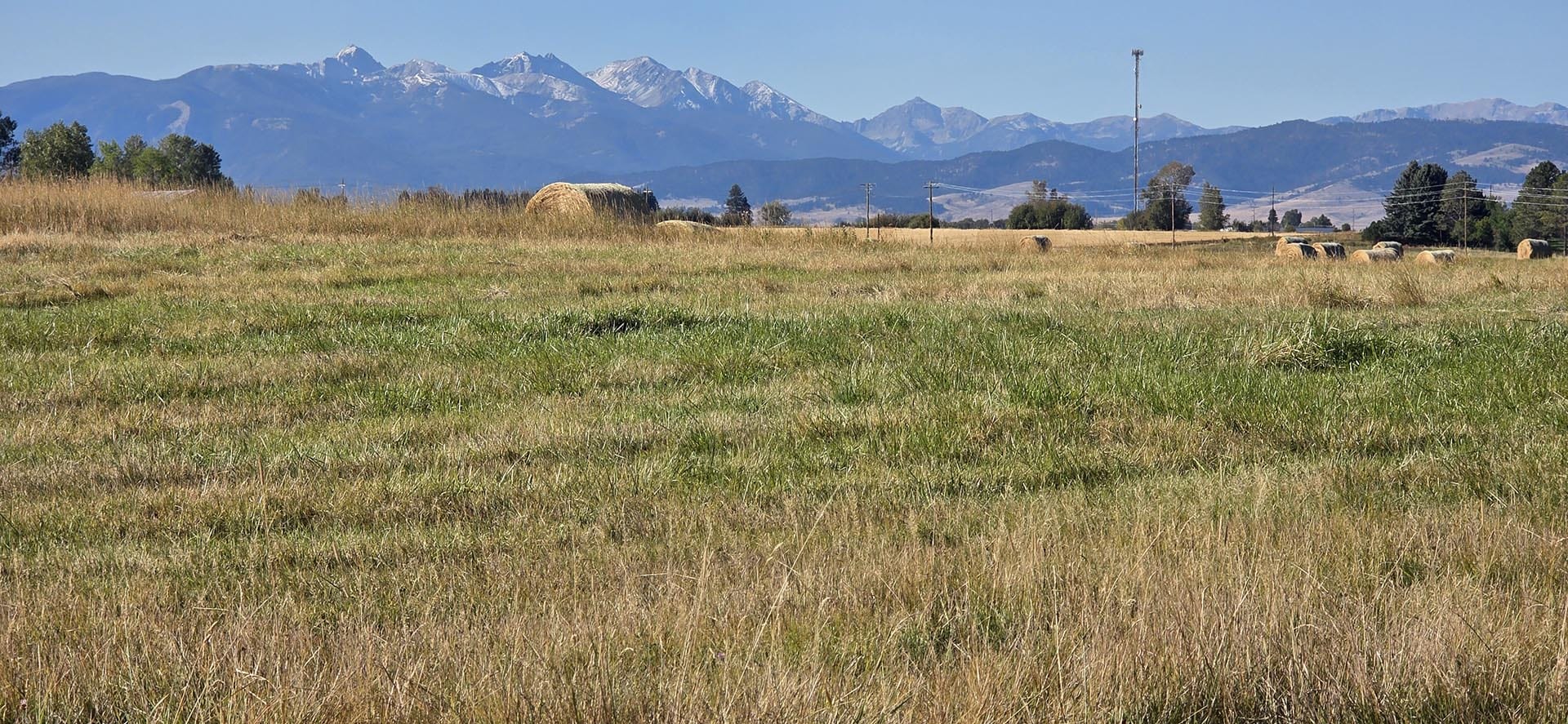 expansive hay fields with mountain backdrop montana west bozeman homestead