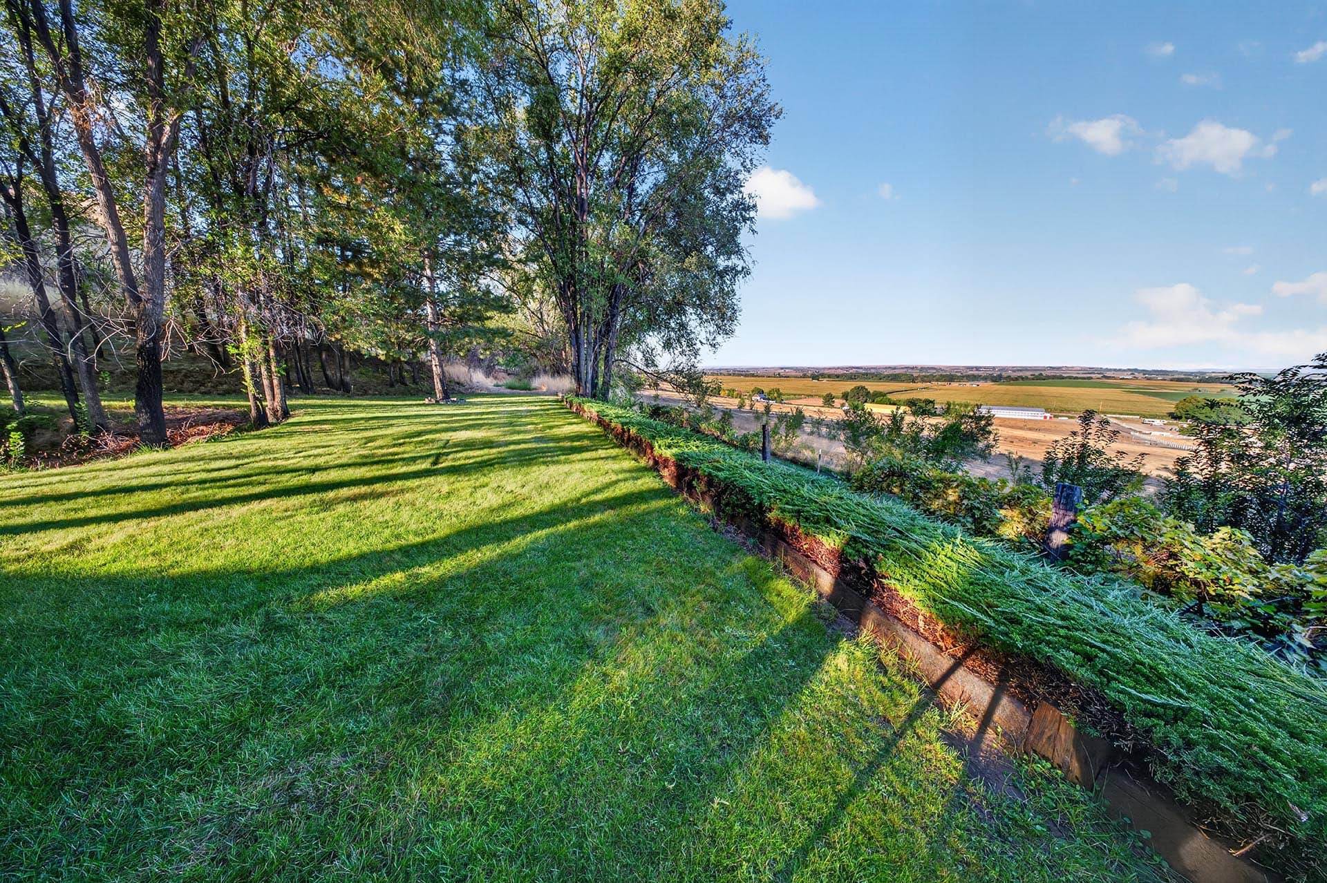 open lawn with tree line and farmland view idaho apple ridge farmstead