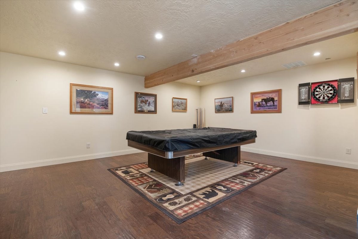 Spacious indoor game room featuring a pool table and artwork on the walls.