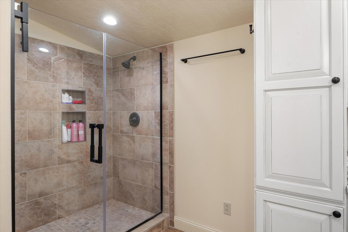Contemporary shower with glass enclosure and built-in shelves.