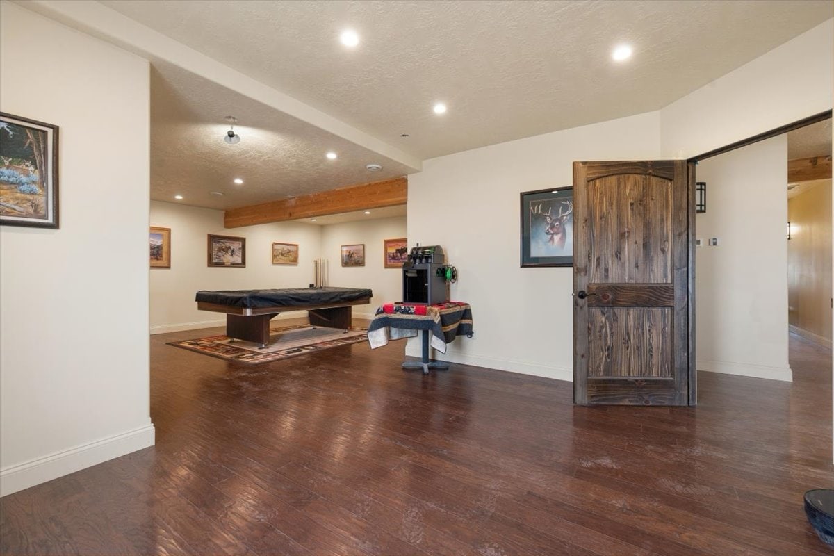 Spacious indoor recreation room with pool table and artwork on walls.
