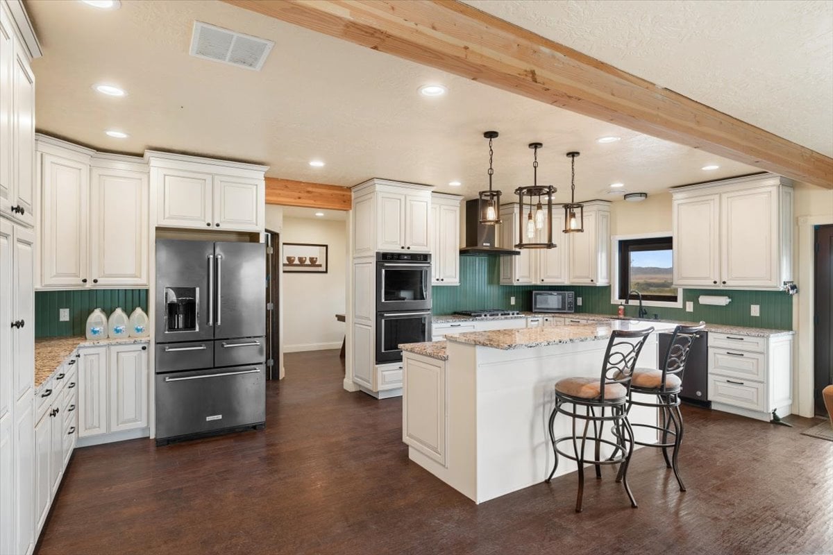 Spacious kitchen with white cabinets, stainless steel appliances, and a central island.